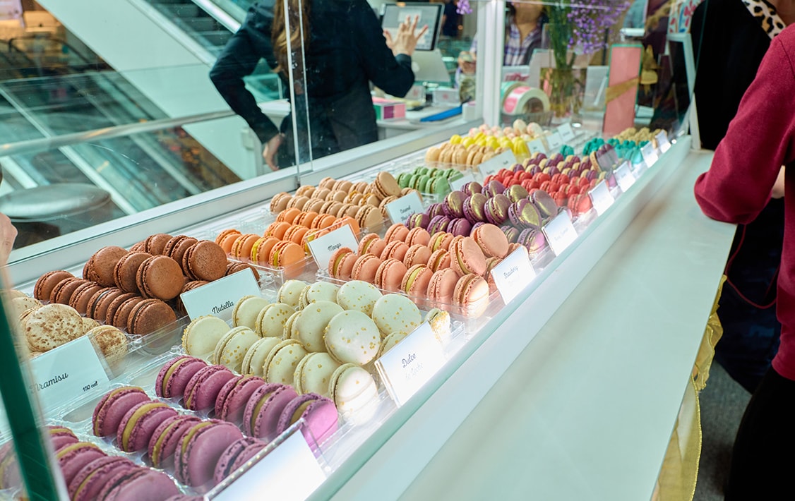 Counter full of assorted Woops! Macarons.