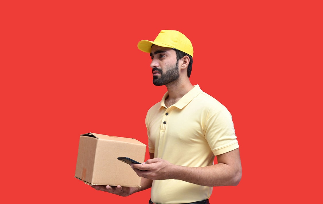 A courier holding a package and wearing a hard yellow hat.